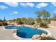 Beautiful pool with rock waterfall feature and surrounding landscaping at 7848 E Parkview Ln, Scottsdale, AZ 85255