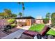 Serene backyard oasis with lush lawn, mature trees, and a charming patio area with lounge chairs at 8230 E Valley Vista Dr, Scottsdale, AZ 85250