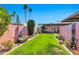 Landscaped backyard with green lawn, privacy wall, and shade trees at 8230 E Valley Vista Dr, Scottsdale, AZ 85250