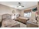 Charming bedroom with twin beds, wicker headboards, ceiling fan, and a window with a decorative valance at 8230 E Valley Vista Dr, Scottsdale, AZ 85250