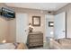 Cozy bedroom featuring two beds, a wall-mounted TV, and a woven dresser with a decorative mirror at 8230 E Valley Vista Dr, Scottsdale, AZ 85250