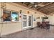 A covered patio that has an outdoor dining area and double glass doors leading inside at 8230 E Valley Vista Dr, Scottsdale, AZ 85250