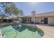 Backyard pool with covered patio, grill, and lush landscaping at 8984 E Sutton Dr, Scottsdale, AZ 85260