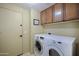 Functional laundry room with washer, dryer, and upper cabinets for storage at 9576 E Kiisa Dr, Scottsdale, AZ 85262