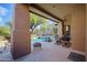 Inviting covered patio with stone floors, outdoor seating, and a view of the sparkling pool at 9576 E Kiisa Dr, Scottsdale, AZ 85262