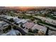 An aerial view captures multiple homes, a golf course, and the tranquil residential area with stunning sunset lighting at 10006 N 79Th Pl, Scottsdale, AZ 85258