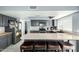 Modern kitchen with stainless steel appliances, tile countertops, breakfast bar, and gray cabinets at 10008 N 50Th Dr, Glendale, AZ 85302