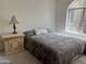 Cozy bedroom featuring an arched window and decorative lamp on the nightstand at 10080 E Mountain View Lake Dr # 138, Scottsdale, AZ 85258