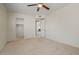 Bedroom with tan carpet, a ceiling fan, and a walk-in closet; view into another room at 11333 N 92Nd St # 2072, Scottsdale, AZ 85260