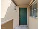 A beautiful teal front door with a glass window to the right, set in a tan wall, and a sconce light above at 11333 N 92Nd St # 2072, Scottsdale, AZ 85260