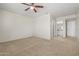 A carpeted main bedroom with a ceiling fan and light, one window, and an attached bathroom at 11333 N 92Nd St # 2072, Scottsdale, AZ 85260