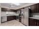 Updated kitchen with stainless steel appliances, granite countertops, and stylish dark brown cabinetry at 1317 E Cobb Dr, Tempe, AZ 85288