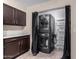 Functional laundry area features stacked washer/dryer, built-in storage cabinets, and tiled floor at 1317 E Cobb Dr, Tempe, AZ 85288