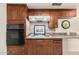 Close-up of the kitchen showing dark wood cabinets, stove, oven, tiled backsplash, and countertop space at 1649 E Dana Ave, Mesa, AZ 85204