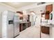 Efficient kitchen layout with stainless steel refrigerator, ample cabinet space, and tiled flooring at 1649 E Dana Ave, Mesa, AZ 85204