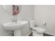Stylish half bathroom with a modern vanity, round mirror, and neutral color palette at 17339 W Paraiso Ln, Surprise, AZ 85387