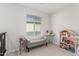 Cozy bedroom with a window, dollhouse, bench, and neutral carpet; perfect for play at 17339 W Paraiso Ln, Surprise, AZ 85387