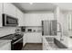 Well-equipped kitchen with white cabinets, stainless steel appliances, granite countertops, and modern fixtures at 17339 W Paraiso Ln, Surprise, AZ 85387