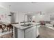 Stylish kitchen island with granite countertop, stainless steel sink, and seating, open to the living room at 17339 W Paraiso Ln, Surprise, AZ 85387
