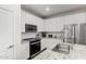 Modern kitchen featuring white cabinets, granite countertops, stainless steel appliances, and a tile backsplash at 17339 W Paraiso Ln, Surprise, AZ 85387