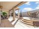 Covered outdoor patio space with dining sets, desert landscaping, steps, and a low privacy wall at 18123 W Hayden Dr, Surprise, AZ 85374