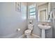 Clean powder room with a pedestal sink, modern toilet, and decorative wall art at 18508 W Galveston St, Goodyear, AZ 85338