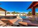 Resort-style backyard with sparkling pool, outdoor seating, rock waterfall and covered pavilion at 19221 N Toya St, Maricopa, AZ 85138