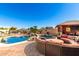 Resort-style backyard with sparkling pool, outdoor seating, rock waterfall and covered pavilion at 19221 N Toya St, Maricopa, AZ 85138
