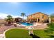 Backyard featuring a pool, rock landscaping, palm trees, lounge chairs, and a covered patio at 19221 N Toya St, Maricopa, AZ 85138
