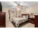 Bedroom featuring neutral walls, ceiling fan, and a floral comforter on the wood bed frame at 19221 N Toya St, Maricopa, AZ 85138