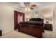 Comfortable bedroom featuring neutral walls, ceiling fan, and a luxurious brown comforter on the wood bed frame at 19221 N Toya St, Maricopa, AZ 85138