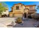 Two-story tan stucco home with a three-car garage and rock landscaping at 19221 N Toya St, Maricopa, AZ 85138