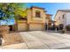 Two-story tan stucco home with a three-car garage and mature landscaping at 19221 N Toya St, Maricopa, AZ 85138