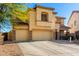 Two-story tan stucco home with a three-car garage and mature landscaping at 19221 N Toya St, Maricopa, AZ 85138