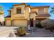 Two-story tan stucco home with a three-car garage and rock landscaping at 19221 N Toya St, Maricopa, AZ 85138