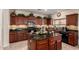 Kitchen with dark wood cabinets, granite countertops, a center island, and stainless steel appliances at 19221 N Toya St, Maricopa, AZ 85138