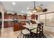 Kitchen and breakfast nook featuring dark wood cabinetry, granite countertops, and a modern ceiling fan at 19221 N Toya St, Maricopa, AZ 85138