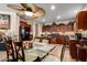 Kitchen with dark wood cabinetry, granite countertops, stainless steel appliances, and a glass-top dining table at 19221 N Toya St, Maricopa, AZ 85138