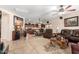Open-concept living room, dining area, and kitchen with dark wood cabinetry and tile flooring at 19221 N Toya St, Maricopa, AZ 85138