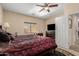 Spacious bedroom featuring a patterned bed, ceiling fan, and a wall-mounted television at 19221 N Toya St, Maricopa, AZ 85138