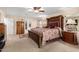Spacious main bedroom features a decorative bed, ceiling fan, and a view of a walk-in closet at 19221 N Toya St, Maricopa, AZ 85138