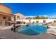 Sparkling pool with custom rock waterfall, ample seating, lush landscaping at 19221 N Toya St, Maricopa, AZ 85138