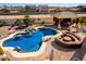 Private backyard showcasing a sparkling pool with waterfall feature and entertainment area at 19221 N Toya St, Maricopa, AZ 85138