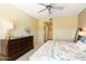 Cozy bedroom with a ceiling fan, dresser, and comfortable bed at 19700 N 76Th St # 1080, Scottsdale, AZ 85255