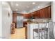 Well-lit kitchen featuring dark wood cabinets, stainless steel appliances, and tile floors at 19700 N 76Th St # 1080, Scottsdale, AZ 85255