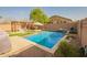 Enjoy a private backyard with a refreshing pool, pergola, lush landscaping, and a built-in waterfall feature at 20325 E Hummingbird Dr, Queen Creek, AZ 85142