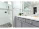 Bathroom vanity area with gray cabinets, decorative tile backsplash, solid surface countertop, and glass enclosed shower at 20325 E Hummingbird Dr, Queen Creek, AZ 85142