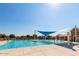 A community pool featuring a shade structure and play features, perfect for Gathering fun on sunny days at 20325 E Hummingbird Dr, Queen Creek, AZ 85142