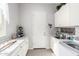 Well-lit laundry room with ample white cabinetry, counter space, and a modern washing machine at 20325 E Hummingbird Dr, Queen Creek, AZ 85142