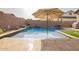 Beautiful pool with an umbrella, turf, and tanning shelf in a private backyard oasis at 20325 E Hummingbird Dr, Queen Creek, AZ 85142